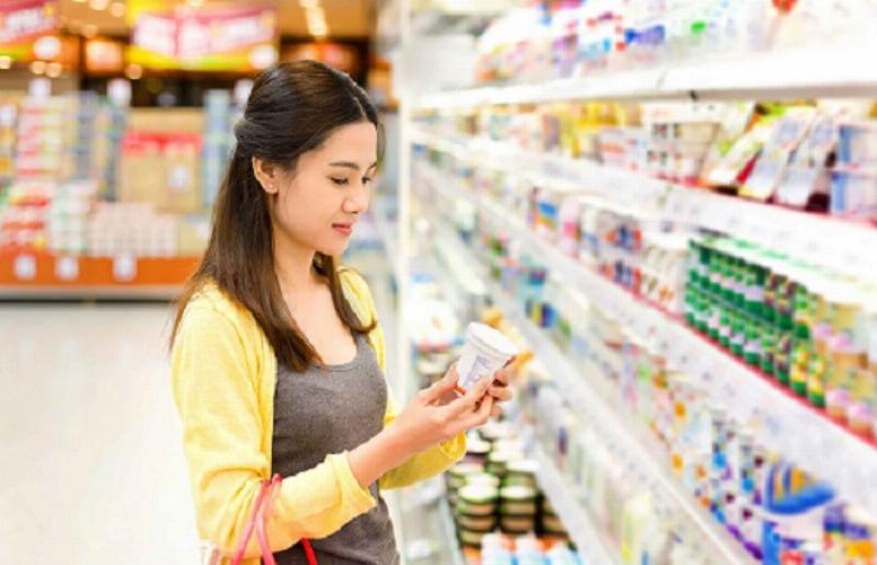 Một người trẻ đang cân nhắc lựa chọn giữa các sản phẩm hàng 1:1 khác nhau, thể hiện sự thông minh trong quyết định mua sắm